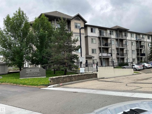 Multi-story residential building featuring private balconies, individual windows, exterior lighting, and a paved parking area - 408 309 Clareview Station Drive Nw, Edmonton, AB 