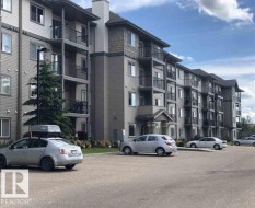 The property features a multi-story building with balconies, a pitched roof, and an exterior with siding and shingle accents - 