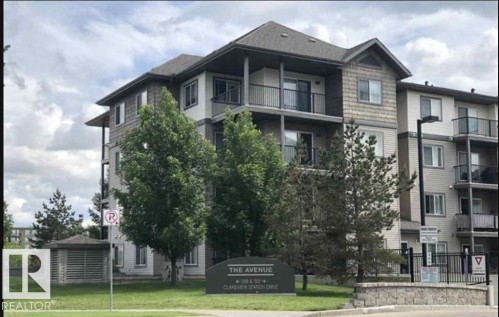 The property features a multi-story exterior with balconies, a dark-colored roof, and a combination of siding materials, including horizontal panels and shingle-style accents - 408 309 Clareview Station Drive Nw, Edmonton, AB - Outdoor With Balcony With Facade