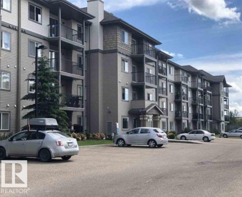 The property features a multi-story building with balconies, a pitched roof, and an exterior with siding and shingle accents - 408 309 Clareview Station Drive Nw, Edmonton, AB - Outdoor With Balcony With Facade