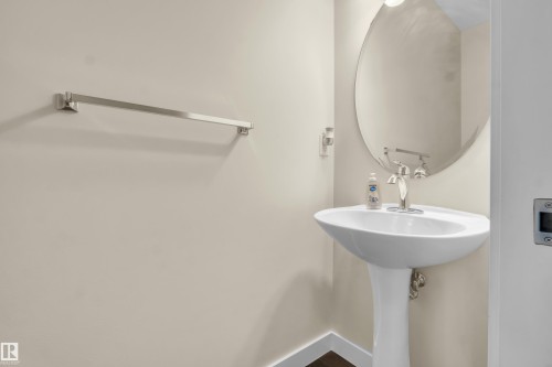Well-appointed bathroom featuring a pedestal sink, an oval mirror, and a towel bar - 3071 Carpenter Landing Landing, Edmonton, AB - Indoor Photo Showing Bathroom