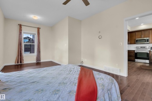 This room features hardwood flooring, a ceiling fan, and light-colored walls - 3071 Carpenter Landing Landing, Edmonton, AB - Indoor Photo Showing Bedroom