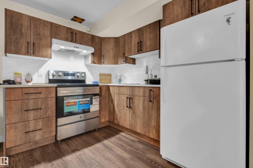 The kitchen features wood cabinetry, white subway tile backsplash, a stainless steel oven with a range hood, and a white refrigerator - 3071 Carpenter Landing Landing, Edmonton, AB - Indoor Photo Showing Kitchen