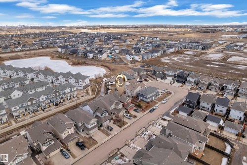 This aerial view showcases the property within a developed residential community, featuring a variety of homes and a nearby pond - 3071 Carpenter Landing Landing, Edmonton, AB - Outdoor With View