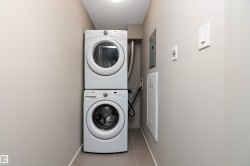 Dedicated laundry area featuring a white stacked washer and dryer unit - 