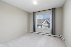 This room features light-colored carpeting, neutral painted walls, and a window with blinds and dark curtains - 