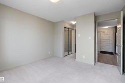 The room features neutral-toned walls, light-colored carpet flooring, and a ceiling light fixture - 