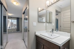 This hallway features mirrored closet doors and leads to a room with a window providing exterior views - 