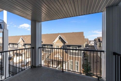 The property includes a private balcony with a concrete floor and black metal railings, offering views of the surrounding neighborhood - 309 4008 Savaryn Drive, Edmonton, AB - Outdoor With Balcony With Exterior