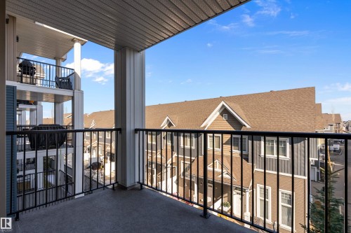 This property features a private balcony with a dark railing and a textured floor - 309 4008 Savaryn Drive, Edmonton, AB - Outdoor With Balcony With Exterior