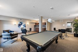 Recreational area featuring a billiards table, lounge seating, and a wet bar with dark cabinetry - 