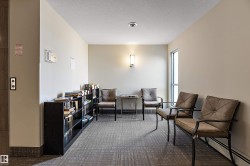 This community waiting area features neutral wall tones, patterned carpet, and a window providing natural light - 