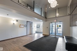 Lobby area featuring tiled flooring, a modern light fixture, and an elevator - 