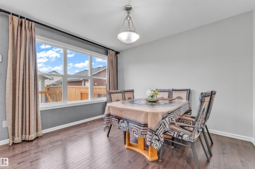 The dining area features hard flooring, a large window with privacy curtains, and an overhead light fixture - 607 Allard Boulevard, Edmonton, AB - Indoor Photo Showing Dining Room