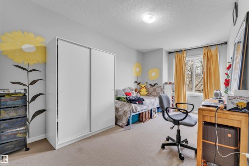 This room features a window with yellow curtains, light-colored walls, and carpeting - 607 Allard Boulevard, Edmonton, AB - Indoor Photo Showing Other Room