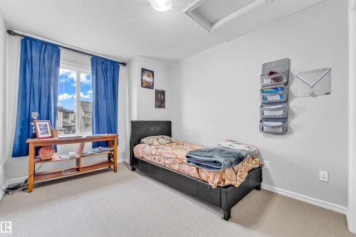 This room features a window providing natural light, a neutral-toned carpet, and light-colored walls - 607 Allard Boulevard, Edmonton, AB - Indoor Photo Showing Bedroom