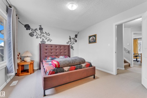 This room features light-colored carpet, a window with curtains, and a light fixture on the ceiling - 607 Allard Boulevard, Edmonton, AB - Indoor Photo Showing Bedroom