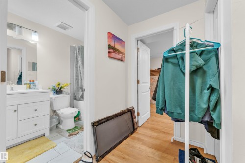 The property features a bathroom with a white vanity, a toilet, and a shower with a shower curtain - 607 Allard Boulevard, Edmonton, AB - Indoor Photo Showing Bathroom