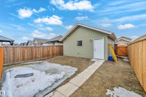 The property features a detached garage with light green siding and a white door, accessible via a pathway of square pavers - 607 Allard Boulevard, Edmonton, AB - Outdoor