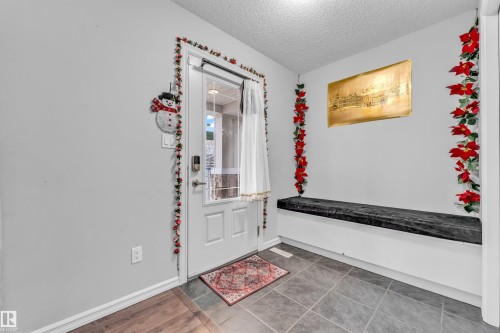 Entryway featuring a white door with a window, tile flooring, and a built-in bench - 607 Allard Boulevard, Edmonton, AB - Indoor Photo Showing Other Room