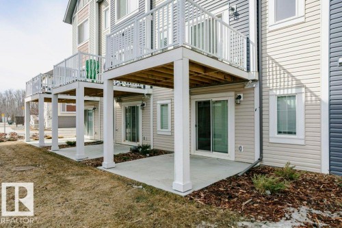 The property features exterior siding, sliding glass doors, and balconies with white railings - 99 320 Secord Boulevard, Edmonton, AB - Outdoor With Balcony