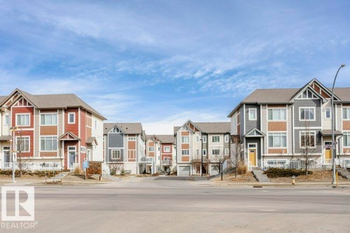 This property features a contemporary architectural style with varied exterior finishes including siding and stone accents - 99 320 Secord Boulevard, Edmonton, AB - Outdoor With Facade