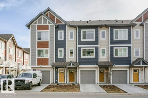 The property features a multi-level design with siding in shades of grey, blue, and brown - 99 320 Secord Boulevard, Edmonton, AB - Outdoor With Facade