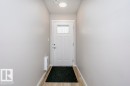 Entryway featuring light-colored walls, wood-look flooring, and a white front door with an integrated window - 99 320 Secord Boulevard, Edmonton, AB  - Indoor Photo Showing Other Room 