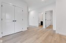 The property features light-colored wood flooring, white walls, and white paneled doors with dark hardware - 20 Meadowgrove Landing, Spruce Grove, AB  - Indoor Photo Showing Other Room 