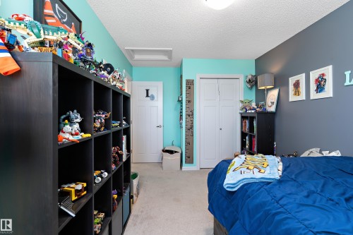 This room features light carpeting, two-tone walls, and a white paneled closet door - 6822 Cardinal Link, Edmonton, AB - Indoor Photo Showing Bedroom