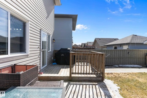 The property features a wooden deck with railing, accessible via a glass-paneled door - 6822 Cardinal Link, Edmonton, AB - Outdoor With Deck Patio Veranda With Exterior