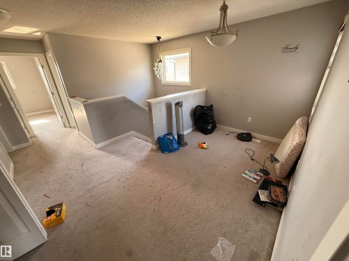 The property features neutral-toned carpeted flooring, light grey painted walls, and white trim - 3317 11 Avenue, Edmonton, AB - Indoor Photo Showing Other Room