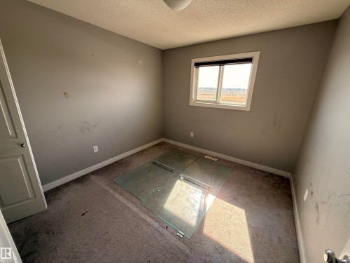 This room features a window providing natural light, a neutral-toned carpet, and a light-colored door - 3317 11 Avenue, Edmonton, AB - Indoor Photo Showing Other Room