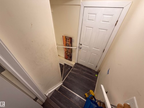 Staircase with dark wood flooring, white walls, and a white panel door - 3317 11 Avenue, Edmonton, AB - Indoor Photo Showing Other Room