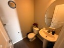 The bathroom features a pedestal sink with a mirror, a toilet, and dark flooring - 3317 11 Avenue, Edmonton, AB  - Indoor Photo Showing Bathroom 