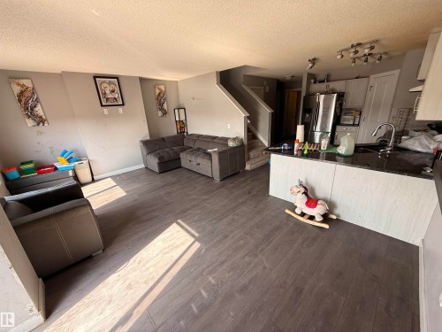 Living room with dark wood-style flooring and a staircase - 3317 11 Avenue, Edmonton, AB - Indoor