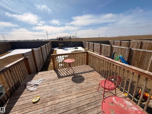The property features a spacious wooden deck overlooking a fenced backyard with a lawn - 3317 11 Avenue, Edmonton, AB - Outdoor With Deck Patio Veranda With Exterior