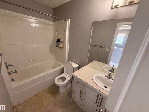 Bathroom featuring a white bathtub, a toilet, and a vanity with a sink and mirror - 3317 11 Avenue, Edmonton, AB - Indoor Photo Showing Bathroom