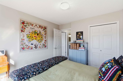 This room features light-colored walls, a ceiling light fixture, and a white interior door - 4750 Crabapple Run, Edmonton, AB - Indoor Photo Showing Bedroom