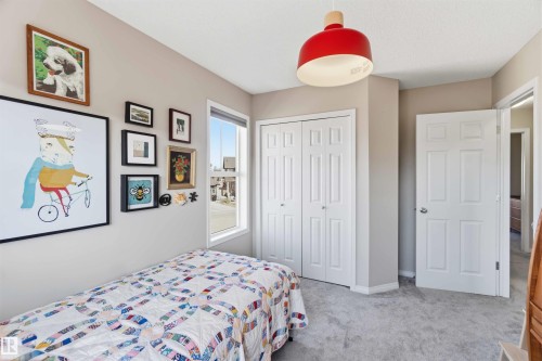 This room features light-colored walls, a window providing natural light, and plush grey carpeting - 4750 Crabapple Run, Edmonton, AB - Indoor Photo Showing Bedroom