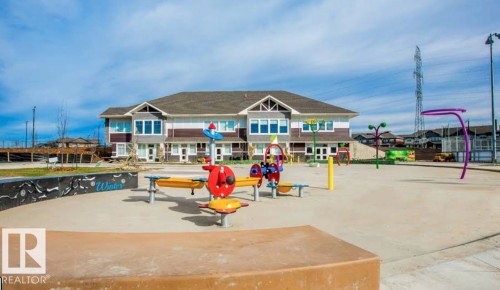 The property is situated near a recreational area featuring a playground with colorful equipment and a paved surface - 4750 Crabapple Run, Edmonton, AB - Outdoor