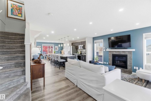 This open-concept living area features light-toned flooring and recessed lighting - 4750 Crabapple Run, Edmonton, AB - Indoor Photo Showing Living Room With Fireplace