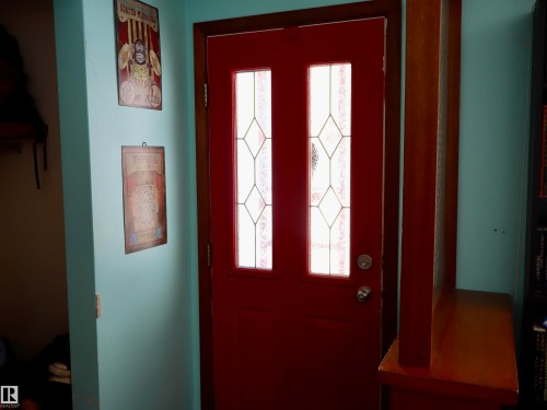 Entryway featuring a red door with decorative glass inserts and a wooden frame - 4315 56 Avenue, Barrhead, AB - Indoor Photo Showing Other Room