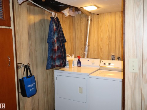 The property includes a laundry area with a white top-loading washing machine and a white front-loading dryer - 4315 56 Avenue, Barrhead, AB - Indoor Photo Showing Laundry Room