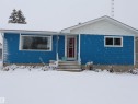 The property features blue siding with white trim, a red entrance door, and a front yard - 4315 56 Avenue, Barrhead, AB  - Outdoor 