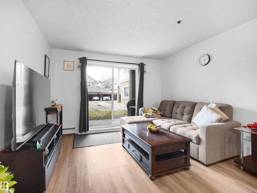 The living room features light-toned flooring and white walls, creating a bright and airy atmosphere - 106 2305 35A Avenue Nw, Edmonton, AB - Indoor Photo Showing Living Room