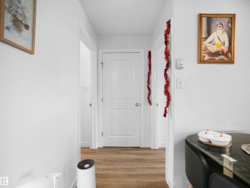 The property features hardwood flooring and white interior doors - 106 2305 35A Avenue Nw, Edmonton, AB - Indoor Photo Showing Other Room