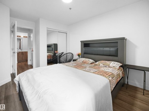 This room features light-colored walls and wood-style flooring, creating a bright and inviting atmosphere - 106 2305 35A Avenue Nw, Edmonton, AB - Indoor Photo Showing Bedroom