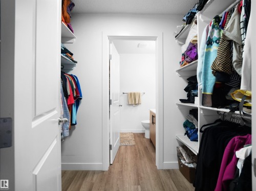 This property features a walk-in closet with built-in shelving and hanging rods, providing ample storage - 106 2305 35A Avenue Nw, Edmonton, AB - Indoor With Storage