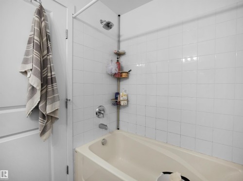 Bathroom featuring a white tiled shower and a bathtub with chrome fixtures - 106 2305 35A Avenue Nw, Edmonton, AB - Indoor Photo Showing Bathroom